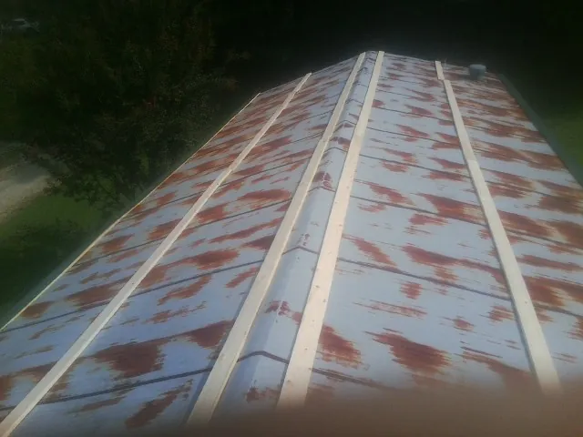 Rusted metal roof panels with new wood purlins before replacement — Storm Damage Roof Repair in Winnebago by Roofing Brothers