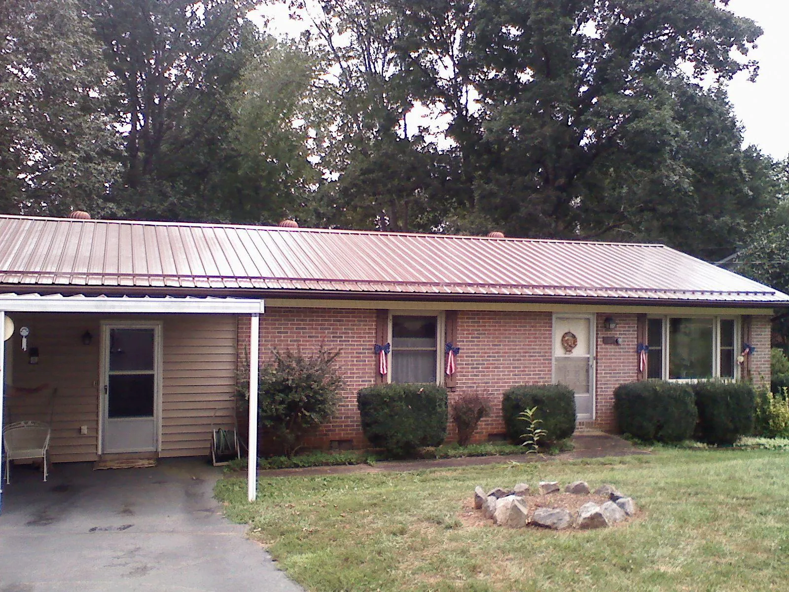 Bronze metal roof and carport on a brick ranch home — Roof Repair work by our crew in Winnebago