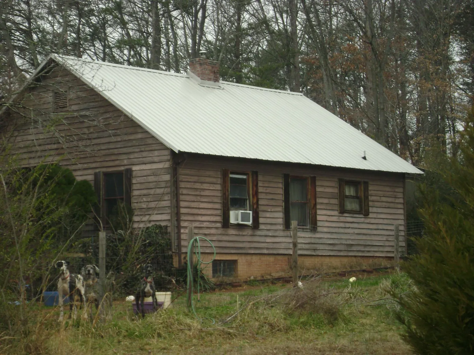 White metal roof on an old wood sided farmhouse, from a Metal Roof Installation job in Winnebago